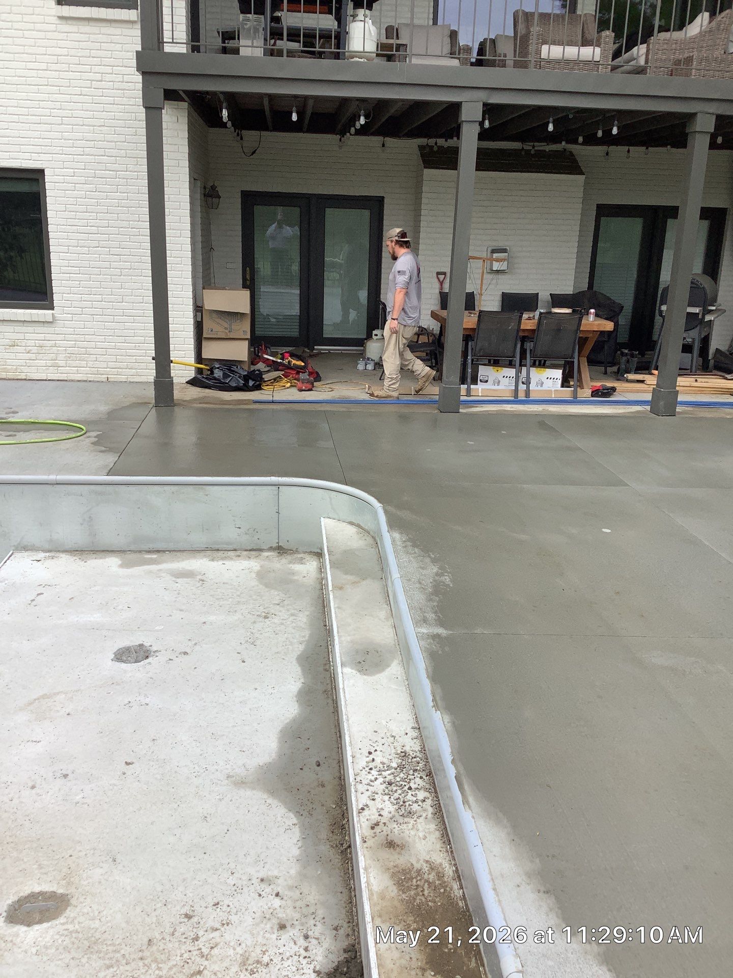 Epp Foundation Repair crew member preparing fresh concrete patio surface at a residential site in Lincoln, NE.